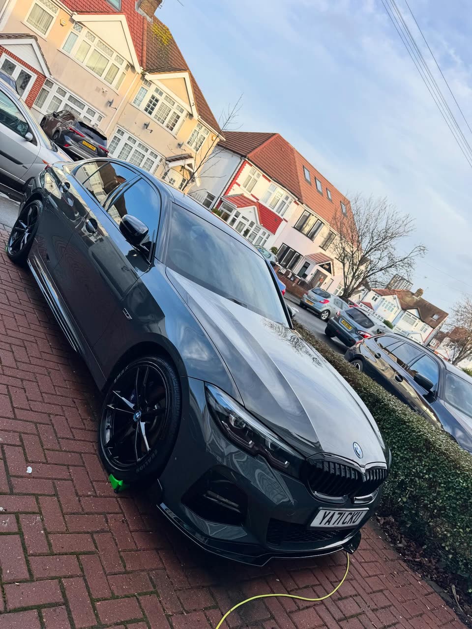 Grey BMW saloon on a block-paved driveway after a detail